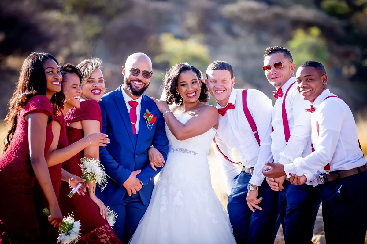 Wedding party of six posing outdoors in formal attire