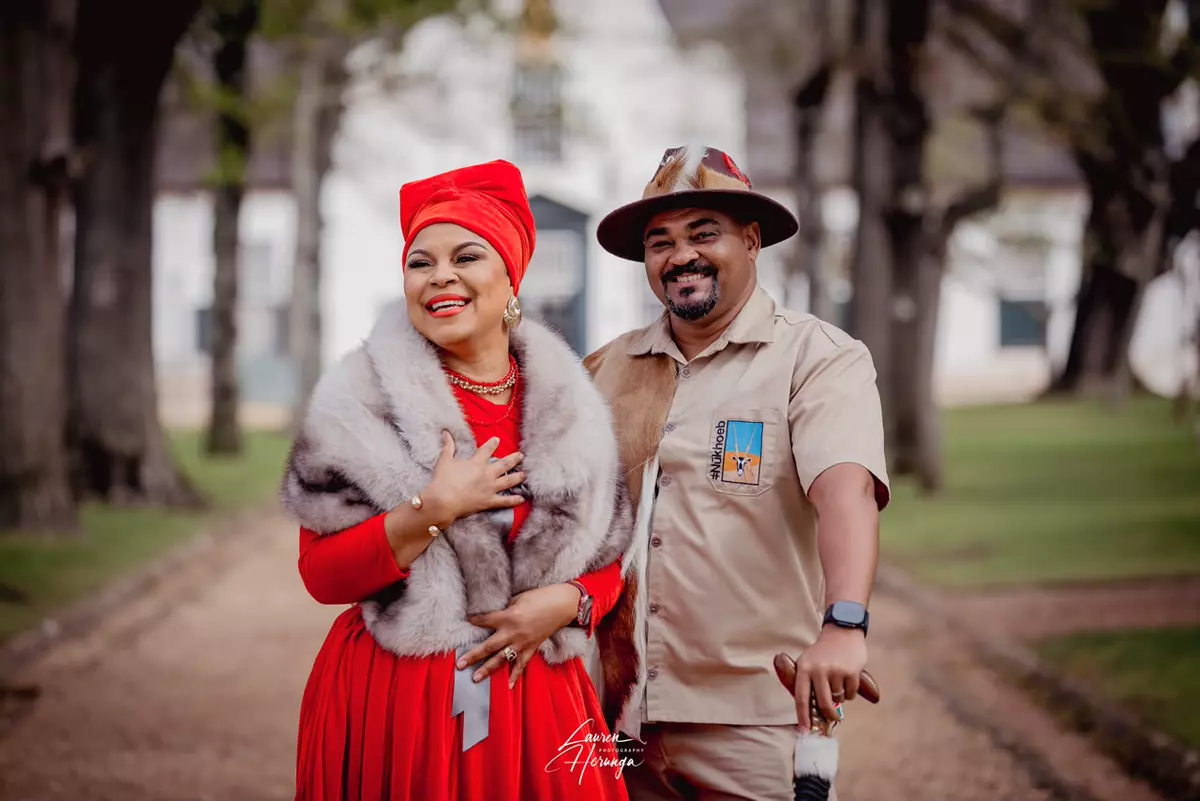 A couple posing outdoors in traditional or safari-themed attire