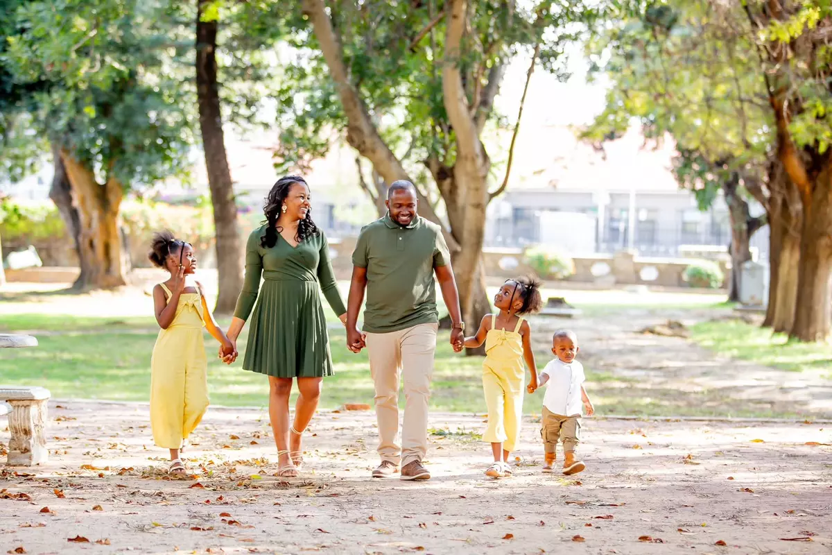 Family of five walking in park