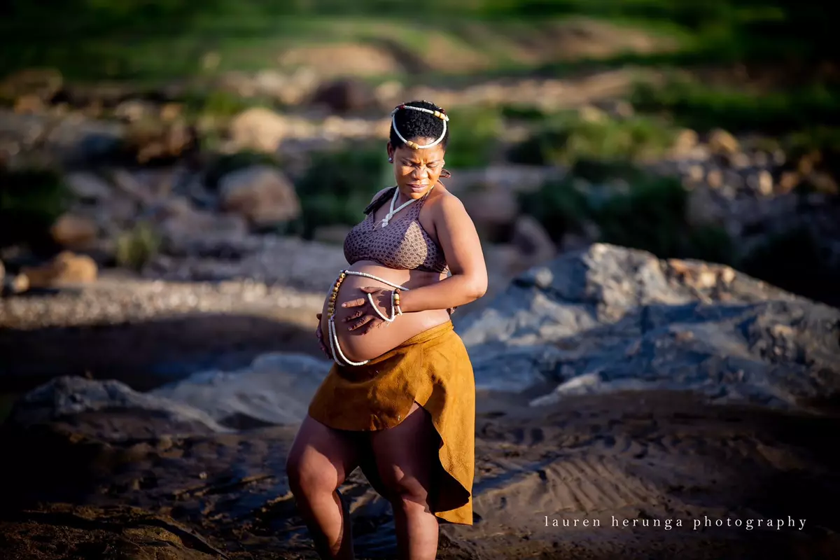 Pregnant woman standing in an outdoor natural rocky setting