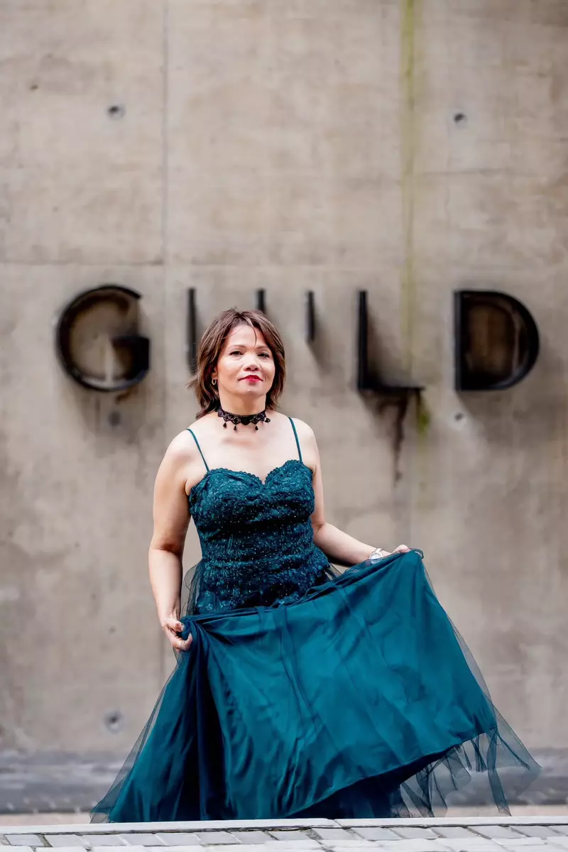 Woman in a dark green dress posing outdoors