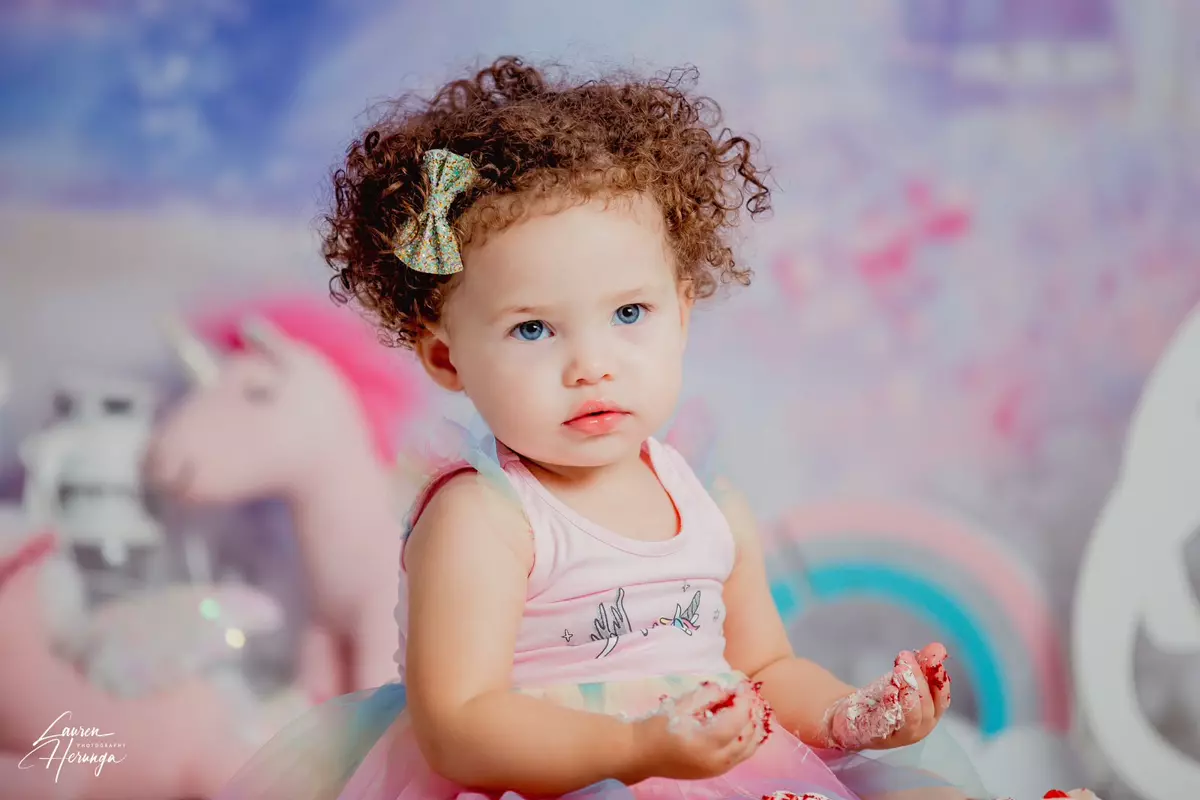 Toddler girl with curly hair and blue eyes