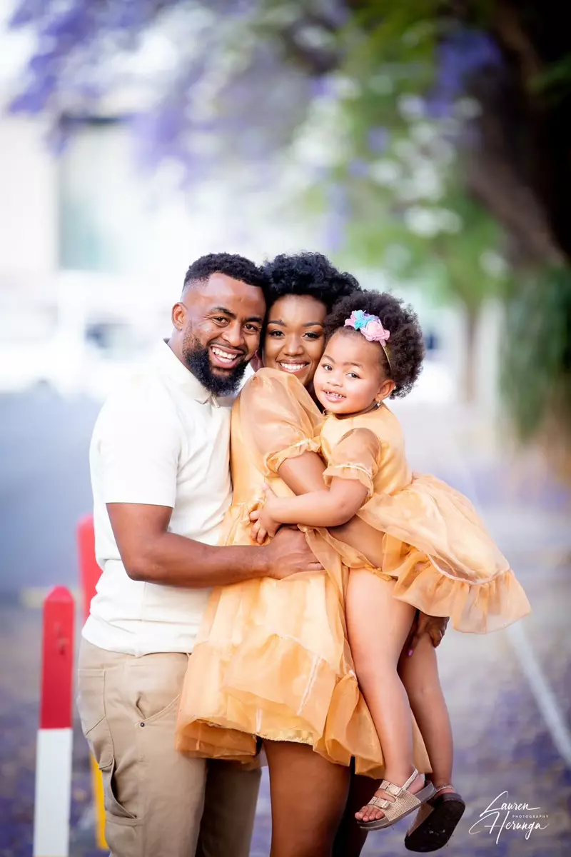 A smiling family of three outdoors