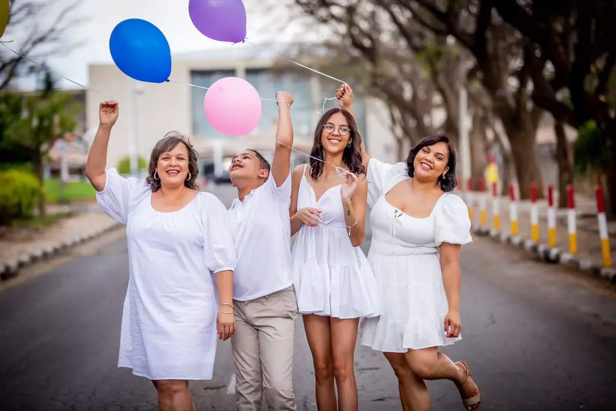 Family walking down an empty street holding colourful balloons